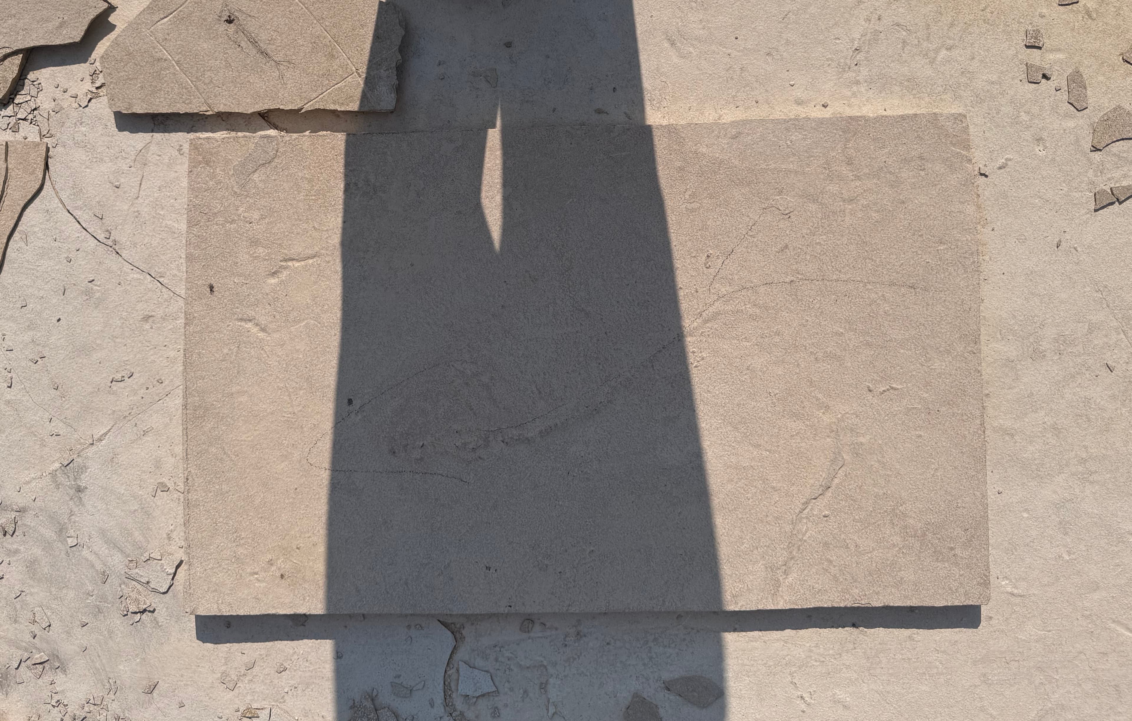 Light casts a long shadow across exposed rock slabs.