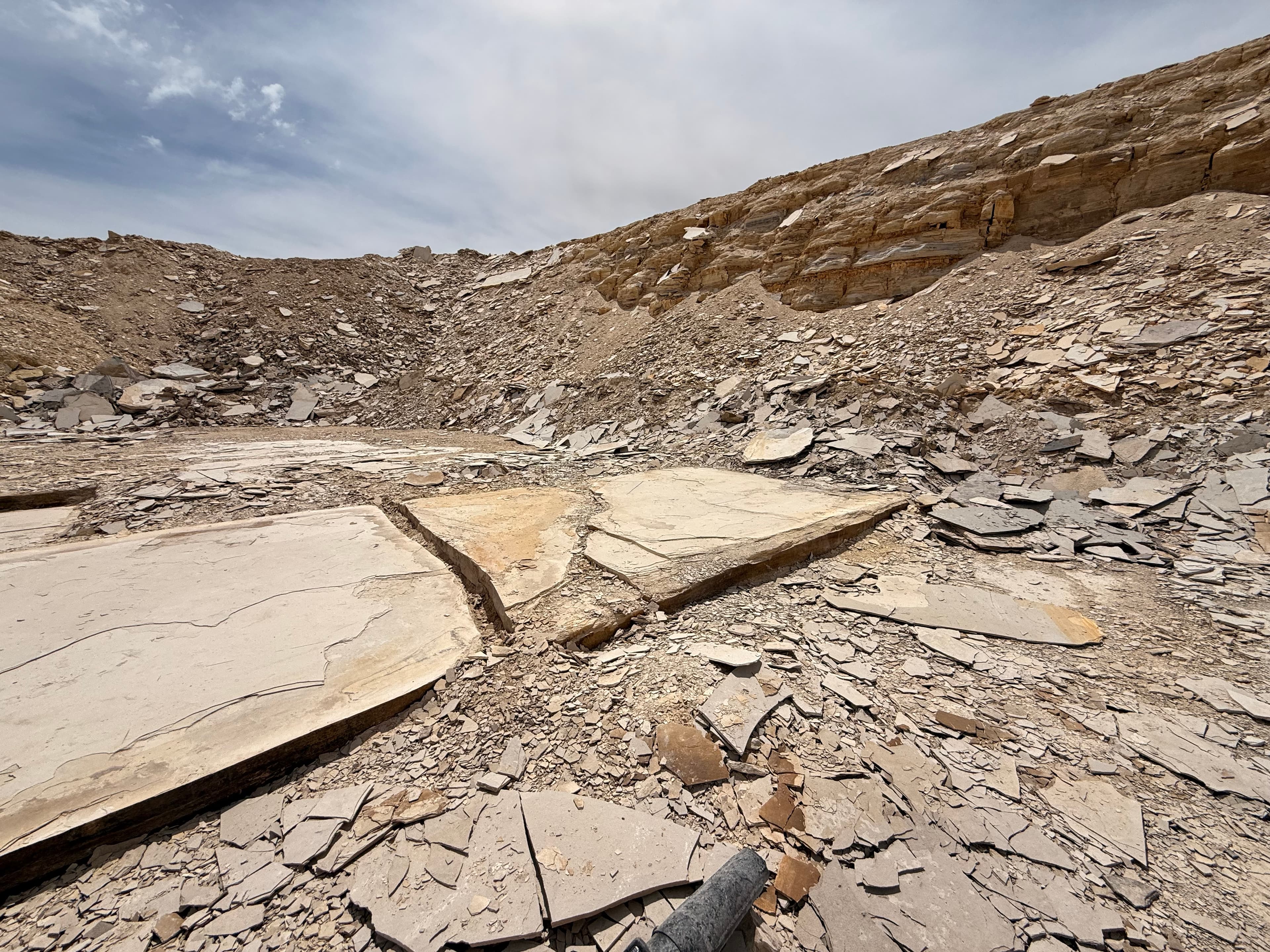 Sunlight illuminates slabs of rock on the quarry floor.