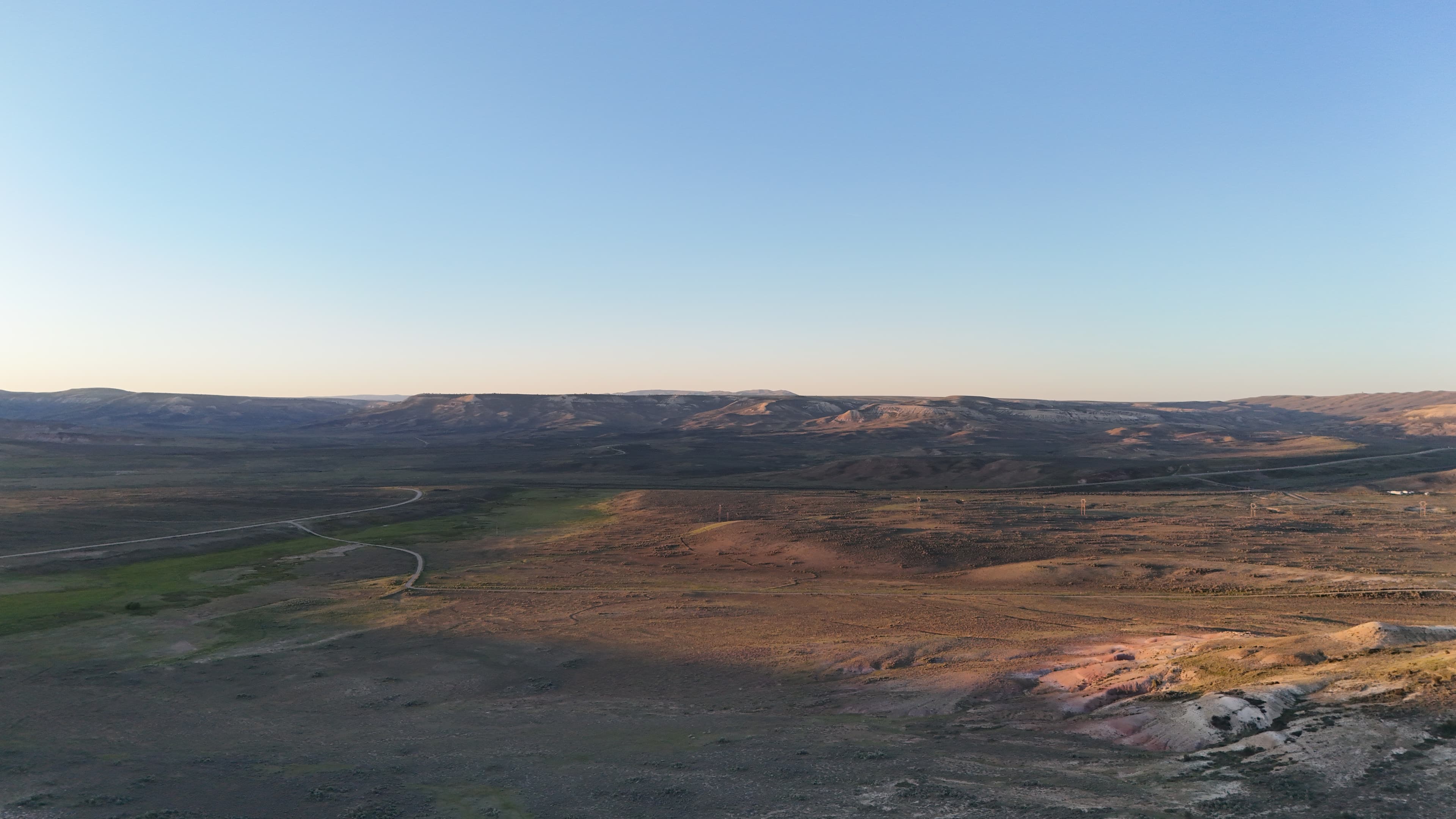 Wide view of hills and valleys under a pale sky.
