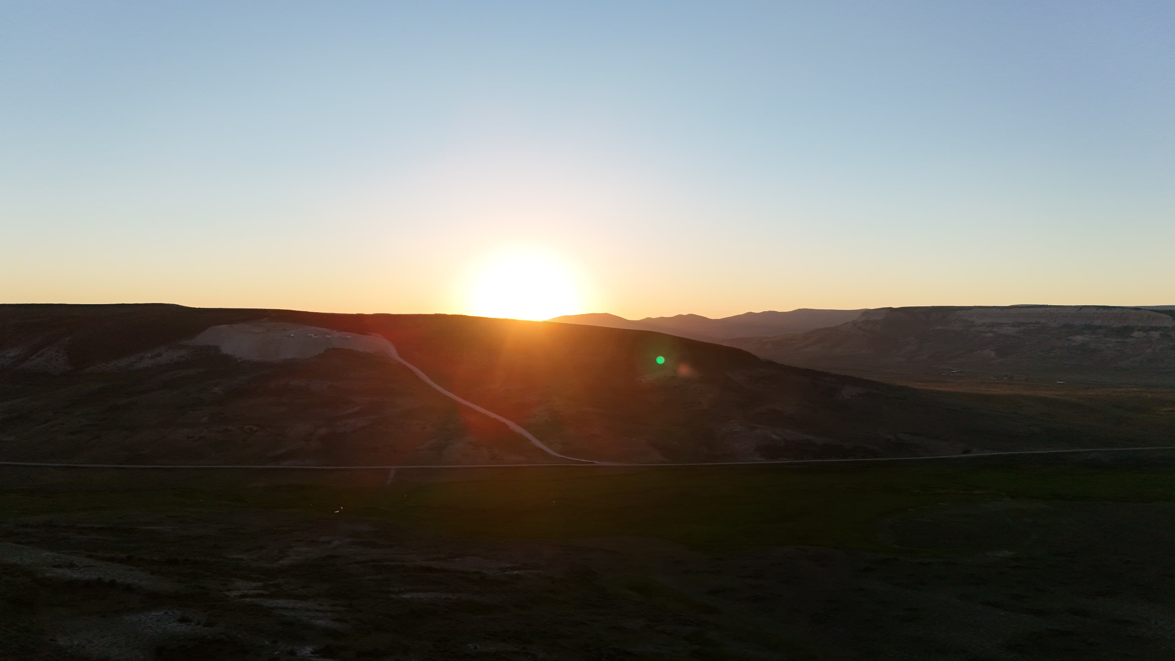 Sunset over distant hills near the dig site.