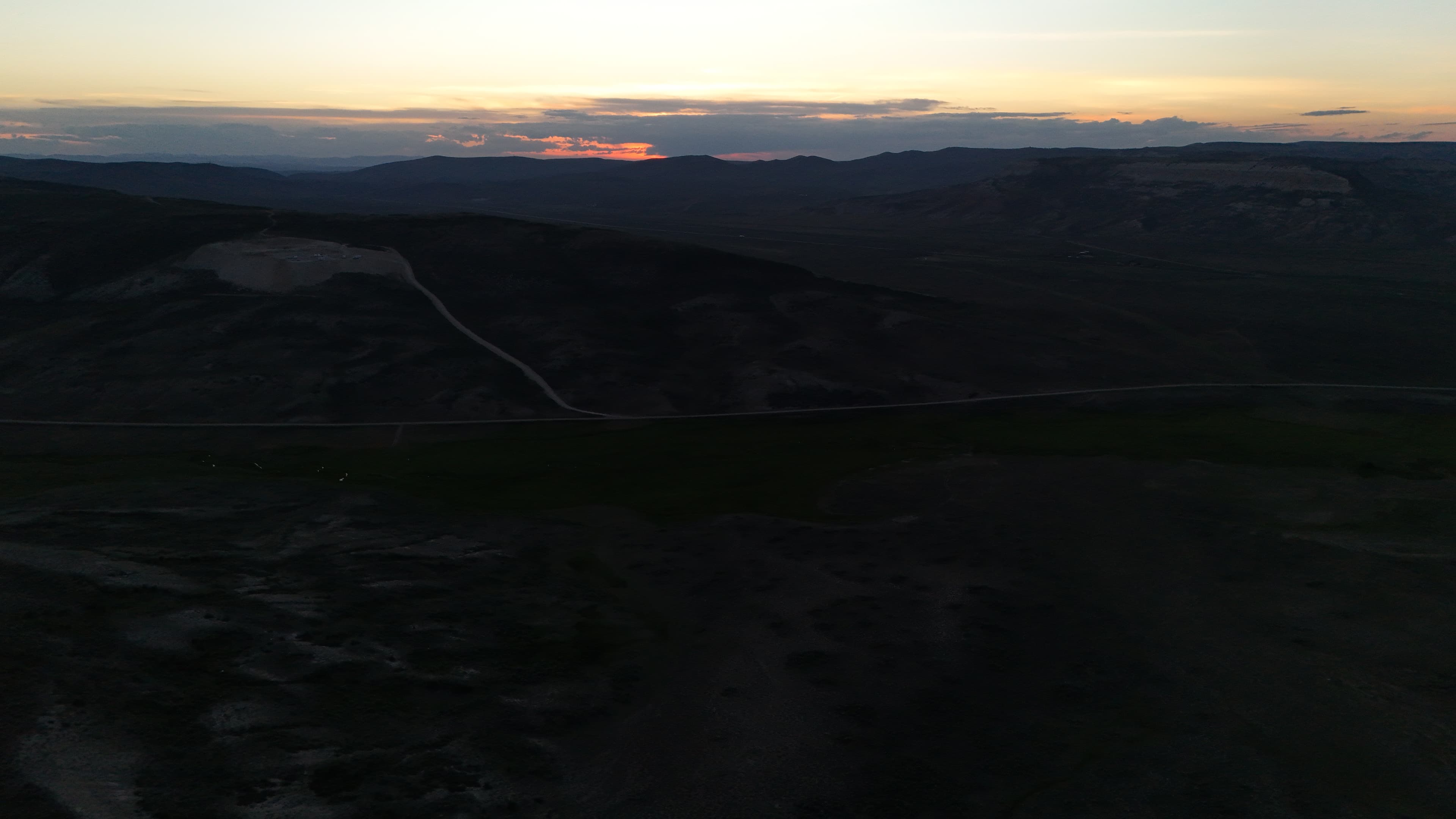 Quarry site in rolling hills at sunset.