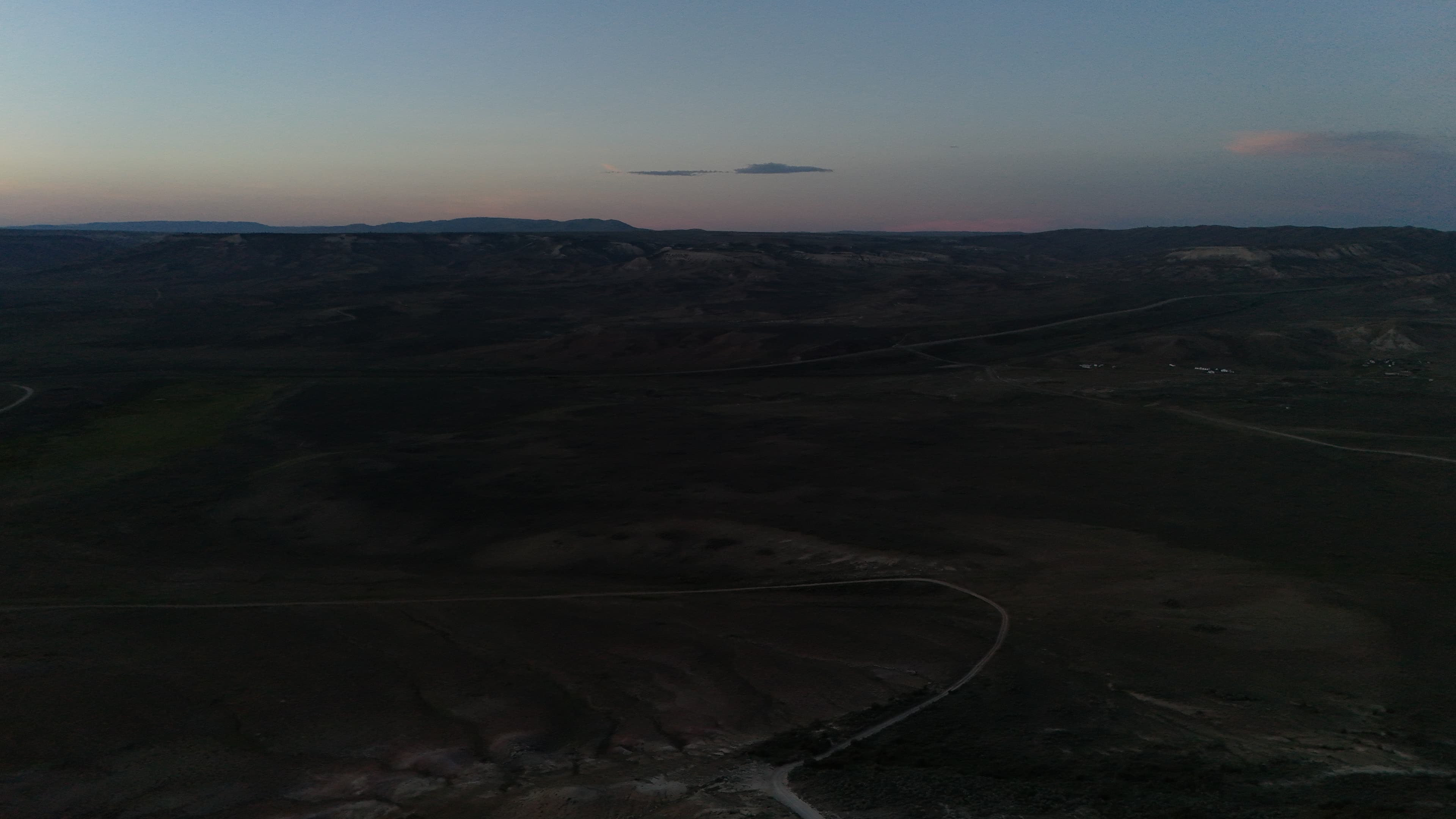 Dusk settles over the Wyoming hills and distant mountains.