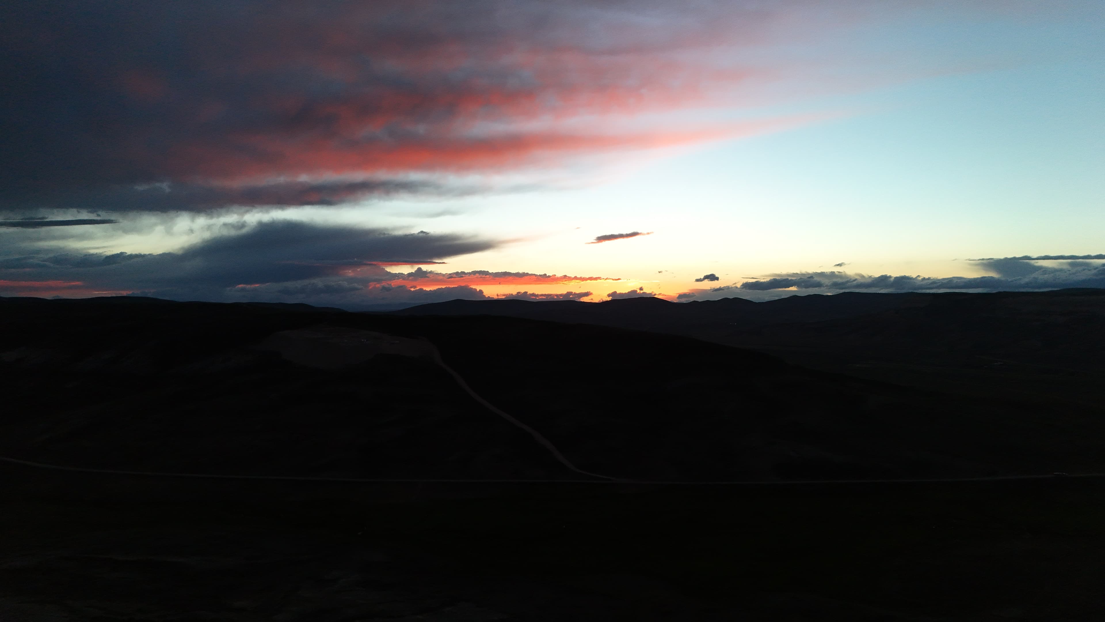 Dramatic clouds over dark Wyoming hills at sunset.