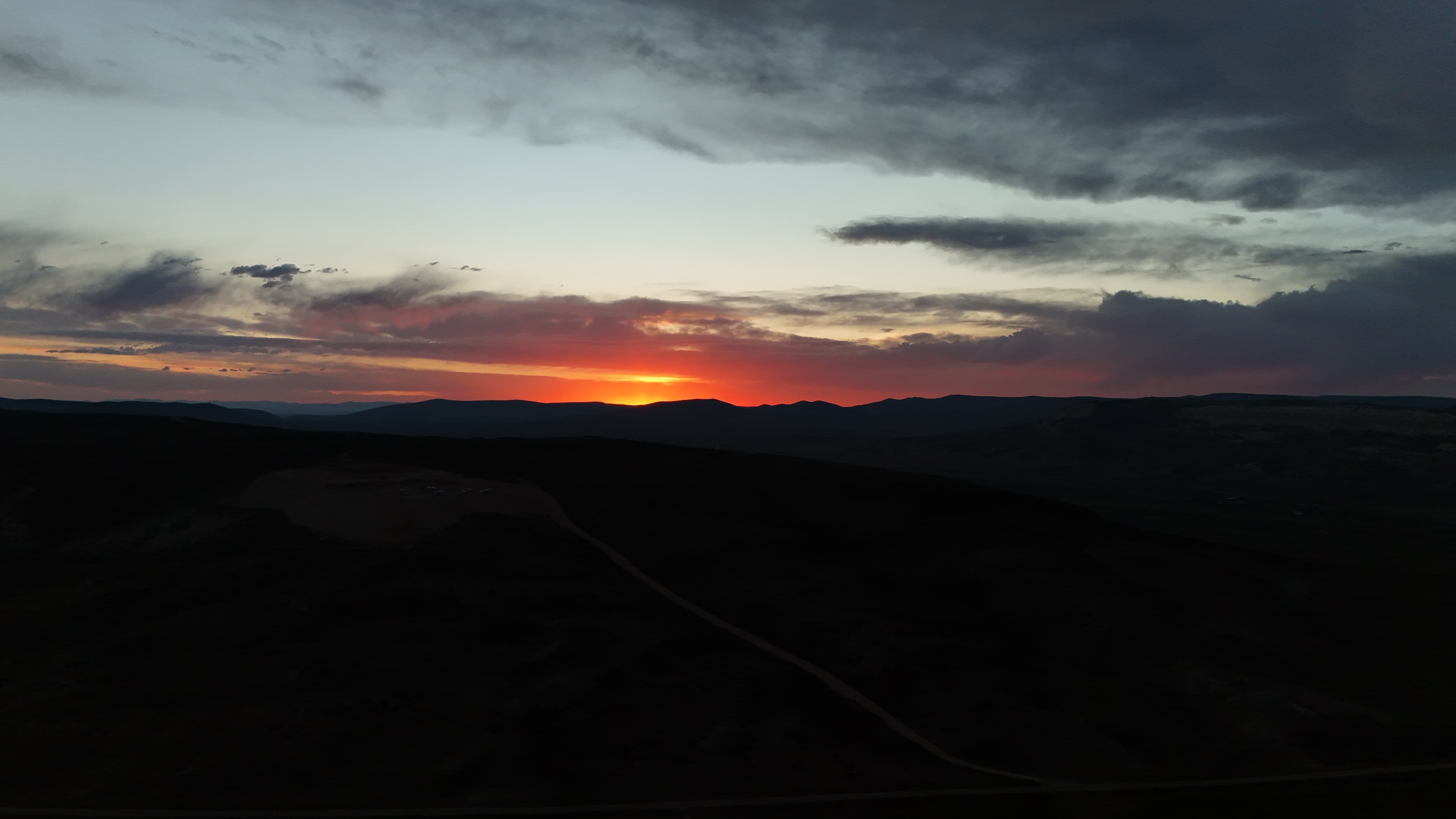 Dusk paints the sky over Wyoming hills and a dark quarry.